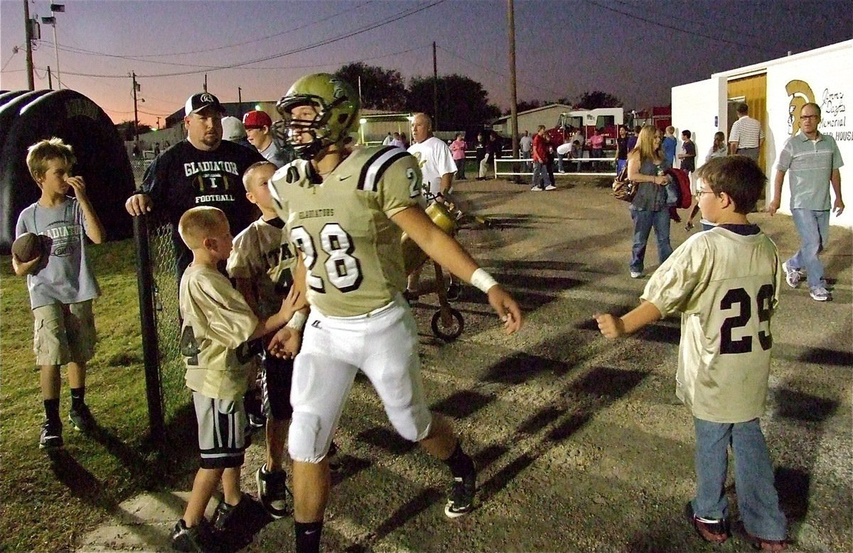 Image: Senior Gladiator Kyle Jackson(28) receives good luck hand slaps from IYAA football players Parker Richters, Ty Cash(24), Jayden Saxon(44) and Gage Wafer(29) before stepping onto Willis Field with his teammates to take on the Buffalo Bison.