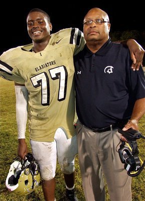 Image: Larry Mayberry, Jr.(77) stands proud with his father and Gladiator assistant coach Larry Mayberry, Sr.