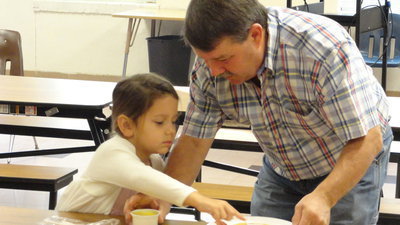 Image: Larry Eubank helps his granddaughter with her pancake.