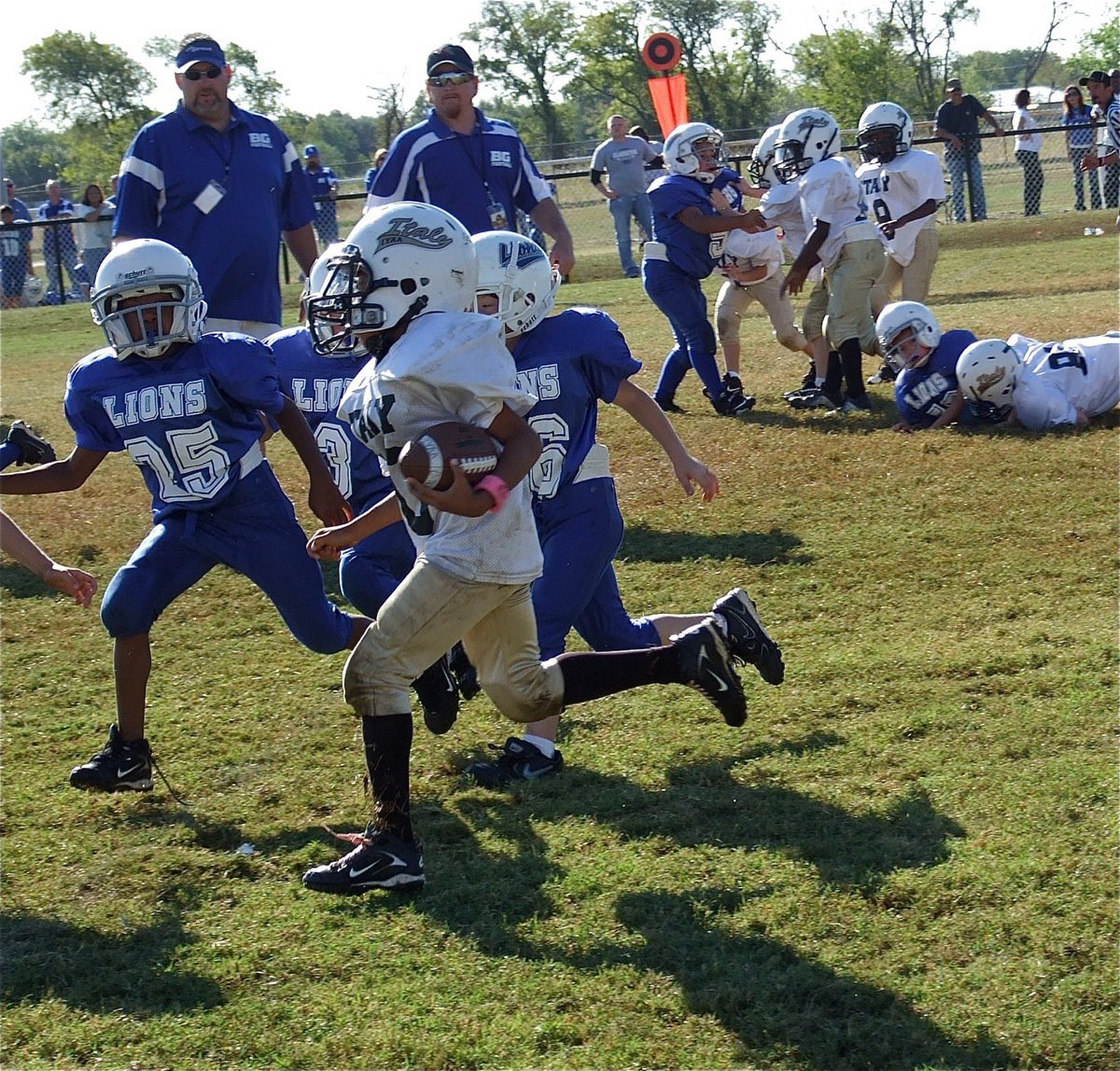 Image: IYAA C-Team quarterback Laveranues Green(10) breaks away from a pack of Lions.