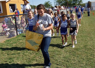 Image: Italy High School junior and B-Team Cheer Coach, Morgan Cockerham, helps her squad welcome Blooming Grove’s cheerleaders to the Italy sideline.