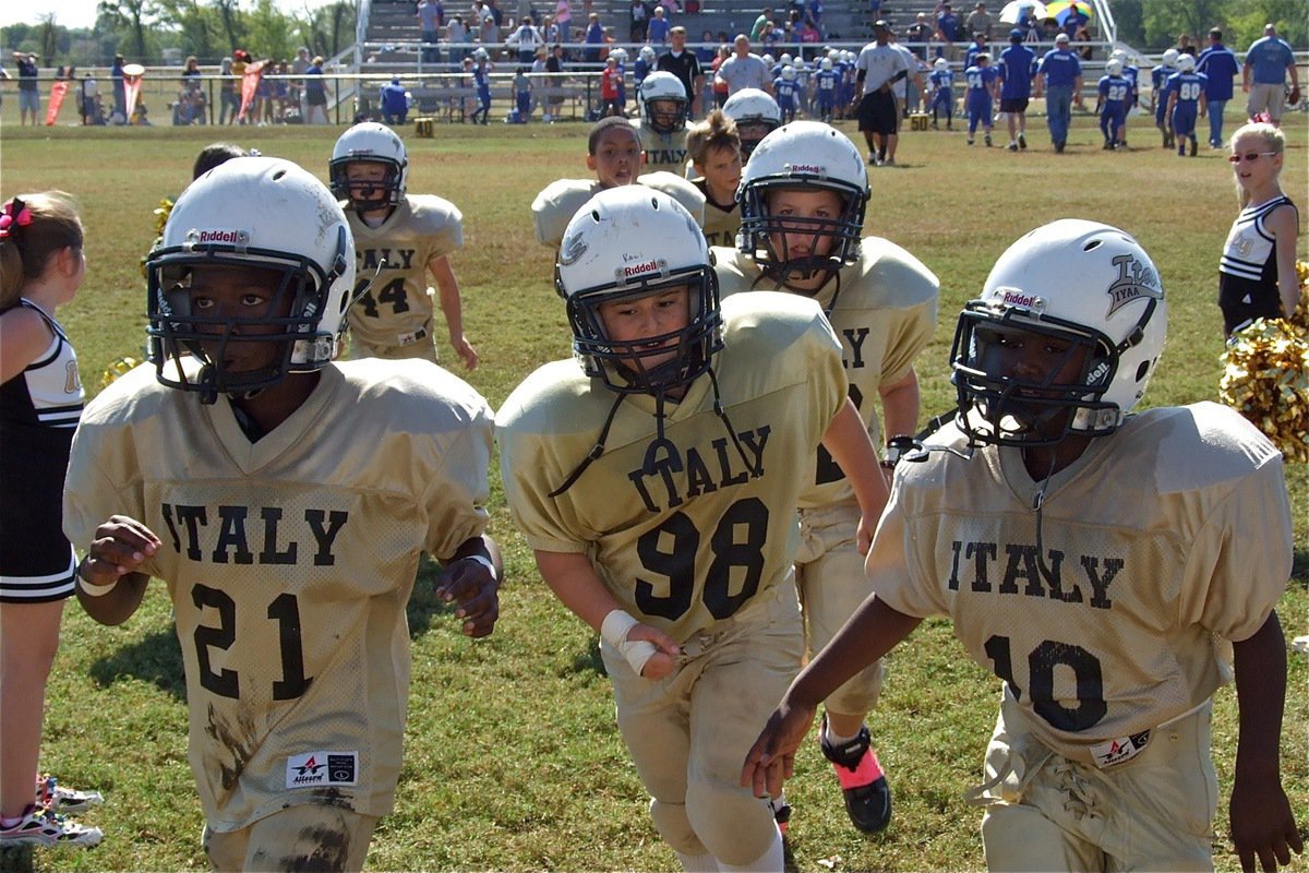 Image: Ricky Pendleton(21), Rocklin Ginnett, Brennon Sigler(82) and Jayden Barr(10) escort their teammates of the field after their 20-0 win over Blooming Grove.