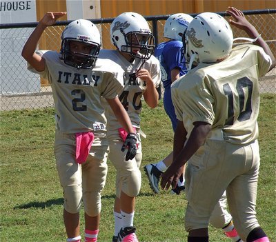 Image: Tylan Wallace(2) salutes Italy’s fans after scoring a touchdown as Gary Scott(40) and Kendrick Norwood(10) congratulate their quarterback as Italy’s A-Team picks up a 20-0 victory over Blooming Grove.