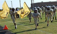 Image: The IYAA B-Team (3rd &amp; 4th grades) charges onto the field to challenge the Mildred Eagles.