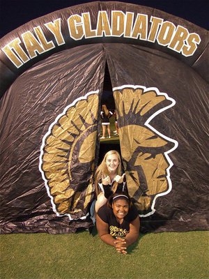 Image: IHS cheerleader Kelsey Nelson and mascot Sa’Kendra Norwood peek out from Italy Gladiator tunnel before the game against Leon.