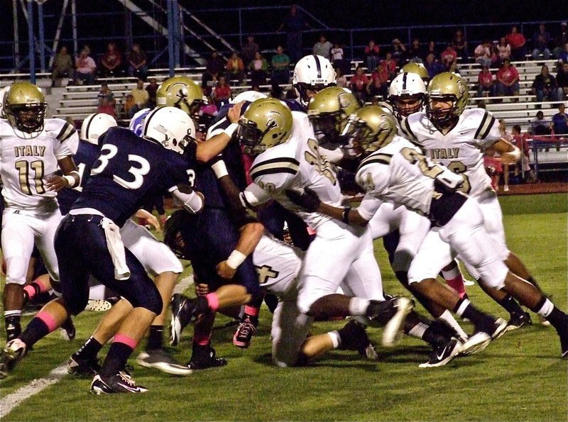 Image: Ethan Saxon(44) wraps up the legs of a Cougar runner as Ryheem Walker(10), Devonta Simmons(9) and Eric Carson(24) hit him high.