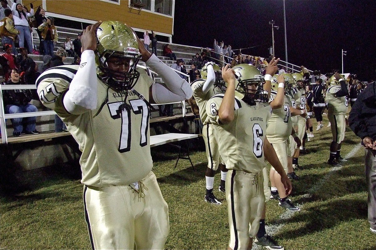 Image: Larry Mayberry, Jr.(77), Tony Wooldridge(6) and several of their Gladiator teammates join their fans during pre-kickoff sword chop. 