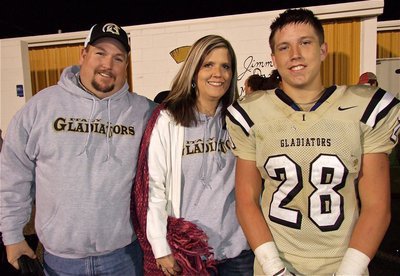 Image: Senior Kyle Jackson(28) stands proud with his parents after Italy’s 36-26 win over Axtell.