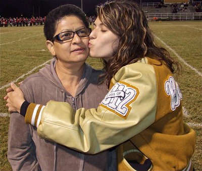 Image: Senior IHS cheerleader, Beverly Barnhart, gives her mom a kiss during their introductions.