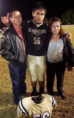 Image: Senior Gladiator, Omar Estrada(56) stands with his proud parents after the Italy win over Axtell as the Gladiators and their fans celebrated Senior Night at Willis Field.