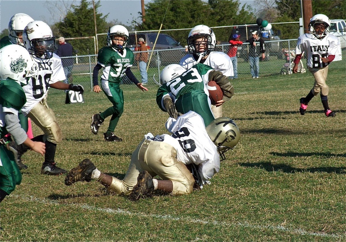 Image: IYAA C-Team noseguard, Byron Davis(99), hauls down a Wildcat runner with teammates Lane Shifflet, Julius Williams(80) and Darrin Jackson(80) closing in.