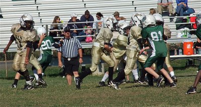 Image: IYAA B-Team back, Preston Rasco(9), takes the handoff from quarterback, Ricky Pendleton(21), and follows his blocker into the hole.