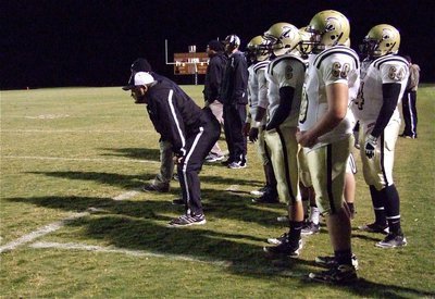 Image: Gladiator head coach Craig Bales uses his old linebacker stance to view the play.
