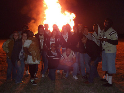 Image: The seniors gather in front of the bonfire for one last bonding moment before the big game.
