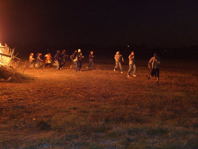 Image: Seniors run the gauntlet around the bonfire for the traditional jaunt around the flames.