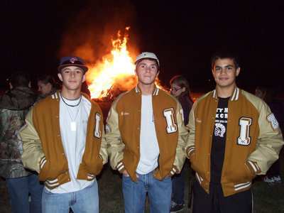 Image: Caden, Brandon and Reid Jacinto hang out in front of the bonfire.