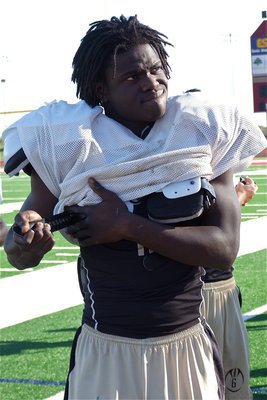 Image: Gladiator Ryheem Walker pulls the straps tight in preparation for the Franklin Lions.