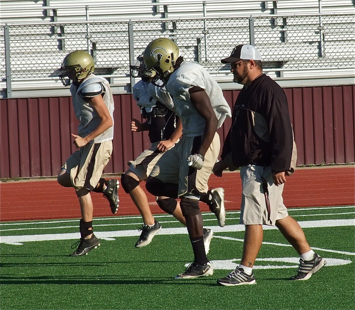 Image: Coach Craig Bales takes his backs thru the paces.