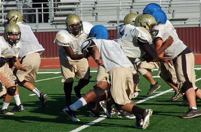 Image: Left guard Adrian Reed(64) pulls and lead blocks during practice.