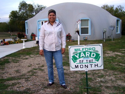 Image: Blanca Figueroa proudly stands next to the ‘Yard of the Month’ sign.