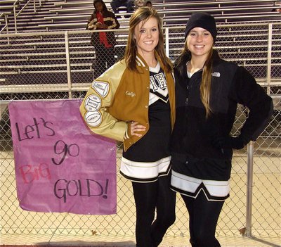 Image: Cheerleaders Kaitlyn Rossa and Madison Washington hang banners along the fence line.