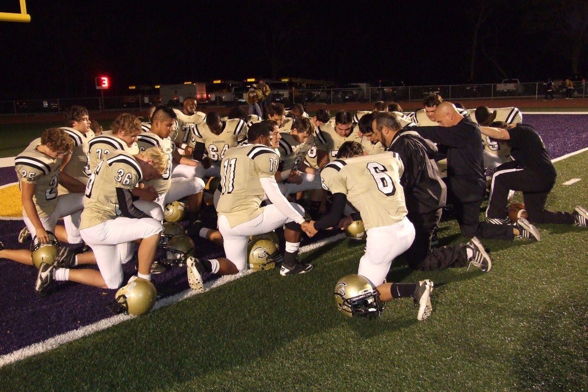 Image: The Gladiators take a knee for a pre-battle prayer.