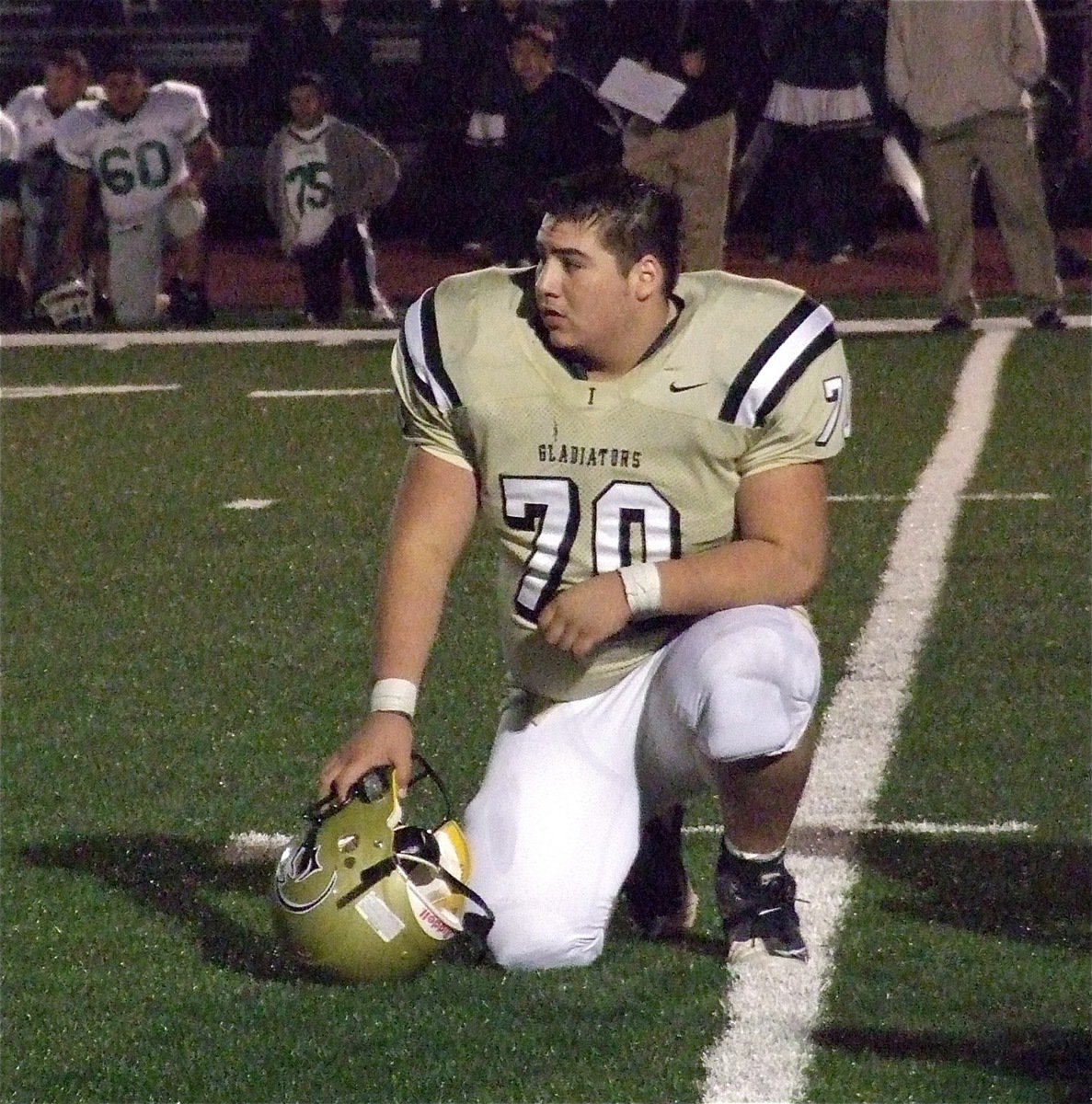 Image: Sportsmanship. Senior Gladiator lineman Isaac Medrano(70) takes a knee during a Franklin injury timeout.