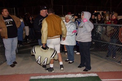Image: Senior Ethan Saxon(44) is greeted by his family as he exits the grid-iron for the final time.