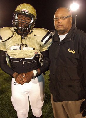 Image: Proud Papa. Gladiator assistant coach, Larry Mayberry, Sr. stands with his son, Larry Mayberry, Jr.(77) after the playoff game against Franklin.