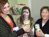 Image: Breanna Smith and Corl McCarthy donate canned goods to the Italy Food Pantry.  Local volunteer, Karen Mathiowetz, gladly accepts food from the ghoulish girls from Necroplex.