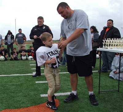 Image: Fleet-footed Lane Shifflet(28) proudly accepts his Superbowl runner-up trophy from his head coach, Aaron Itson.