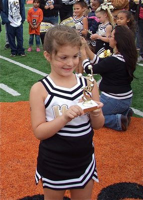 Image: IYAA C-Team cheerleader Taylor Souder is mesmerized by her Superbowl cheerleading trophy.