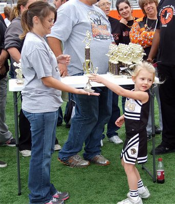 Image: IYAA C-Team cheer coach Jessica Posey presents Jordan Posey with her Superbowl Runner-up trophy.