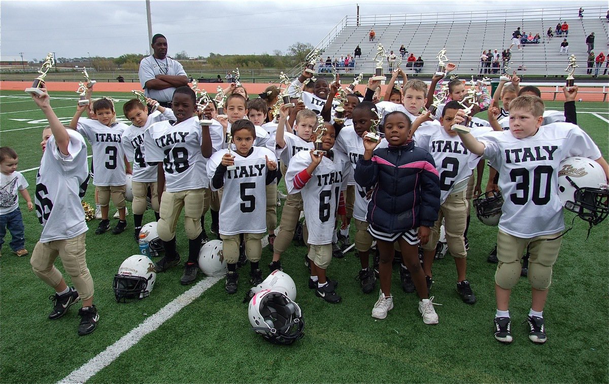 Image: Proud youngsters! The IYAA C-Team players and cheerleaders hold their Superbowl Runner-Up trophies high for all to see.