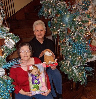 Image: Karen Mathiowetz and Mary Hooser display donated toys at the foot of the staircase which was ornately decorated by Mary Teat.