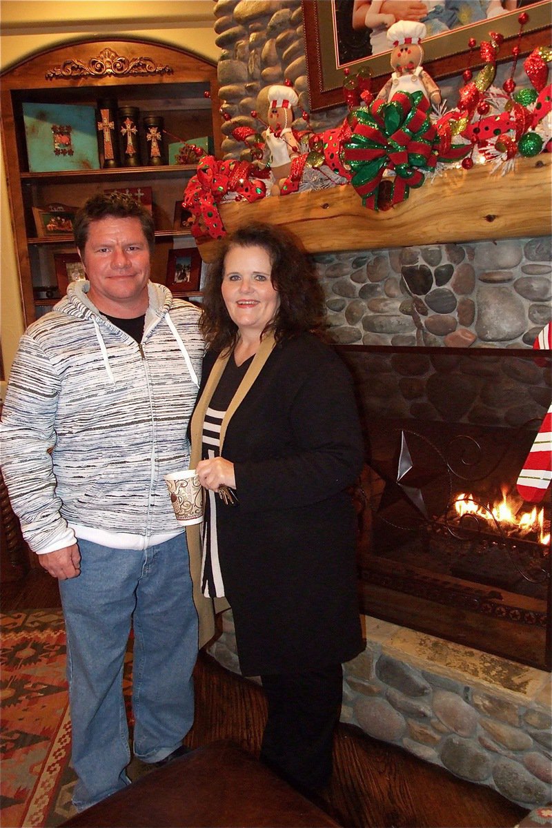 Image: Raymond Mosley and Donna Cate enjoy a cup of hot chocolate near a warm fire inside the Haight home during the toy donation drive.