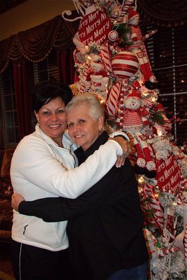 Image: Mary Teat and her mother Mary Hooser hug in front of a Teat decorated tree during the toy drive.