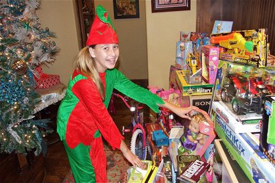 Image: Elf, Hannah Haight, is ready to take in more toy donations for the Italian Festival.