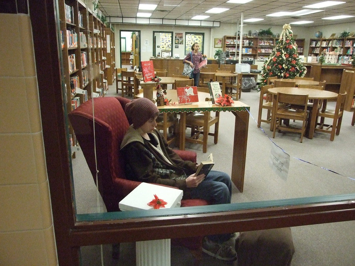 Image: 7th grader, Michael Hughes, enjoys his comfy chair and reads his favorite book while Mrs. Farmer cooks him popcorn and pours hot chocolate.