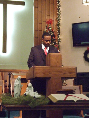 Image: Pastor Mittie Muse read the Christmas story from Luke 2:1-14.