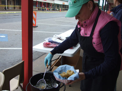 Image: Cynthia Teer takes the fried pickles out of the fryer for the customers standing in line.