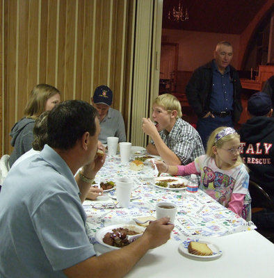 Image: The firemen and their families enjoy bar-b-que cooked by Mt. Zion AME youth.