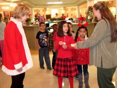 Image: Jan Shepard (2nd grade teacher) watches as each student is given a Christmas cookie.