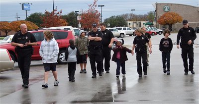 Image: Officers begin planning shopping strategies with the students as the group approaches the Walmart entrance in Waxahachie.