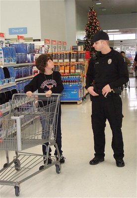 Image: Nicholas and Officer Daniel Pitts get on the same page before racing down the isles looking for gift items.