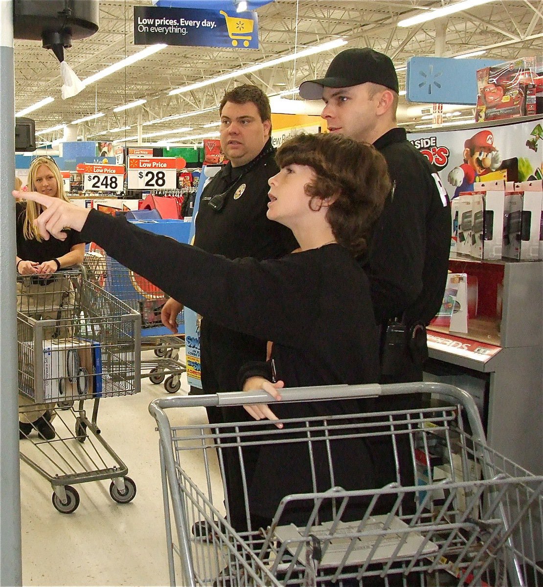 Image: That’s the game I want! Officer Shelbi Landon, Officer Eric Tolliver and Officer Daniel Pitts assist Nicholas in the video game section. 