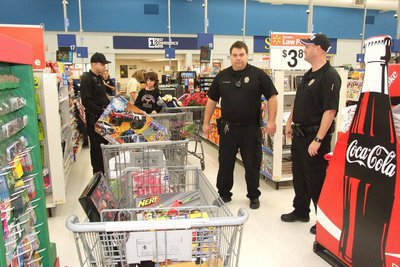 Image: Officer Eric Tolliver realizes this could take awhile as one full shopping cart after another makes their way to the checkout line. 
