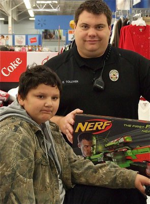 Image: Officer Eric Tolliver surprises Austin with one last toy item before checking out.