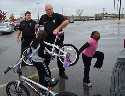 Image: Officer Eric Tolliver supervises while Chief Hill receives assistance from Byron and Mariah.