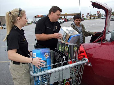 Image: Animal Control Officer Shelbi Landon and Officer Eric Tolliver help load Austin’s gift items.